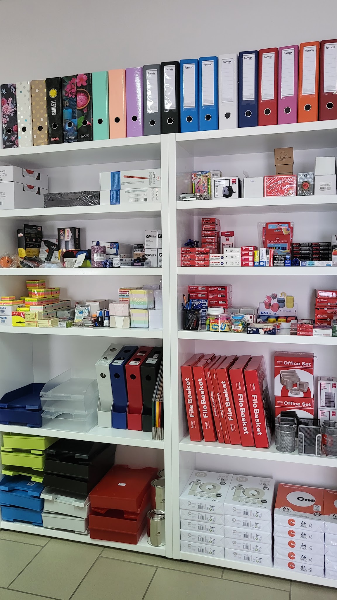Binders, paper and office supplies on shelves inside the shop.